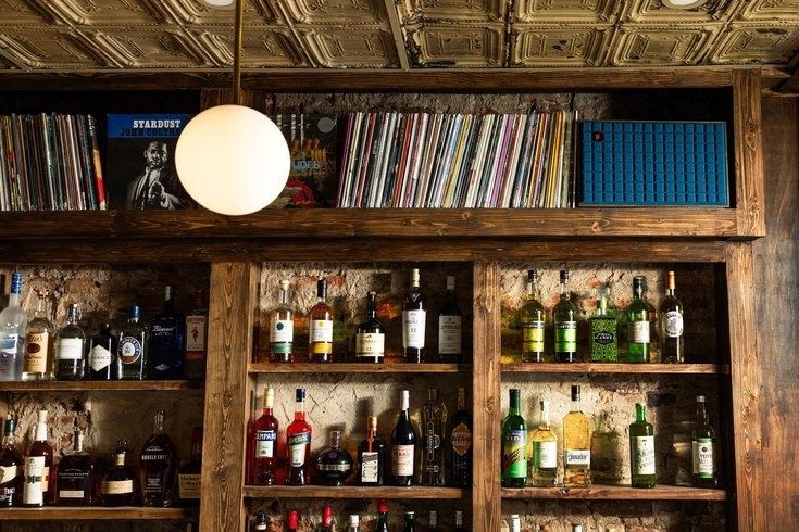 Houten bar met platenkast, platencollectie en flessen sterke drank